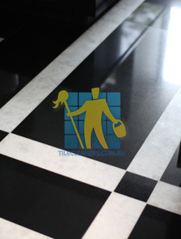 polished black marble tiles with white stripes in a floor pattern 